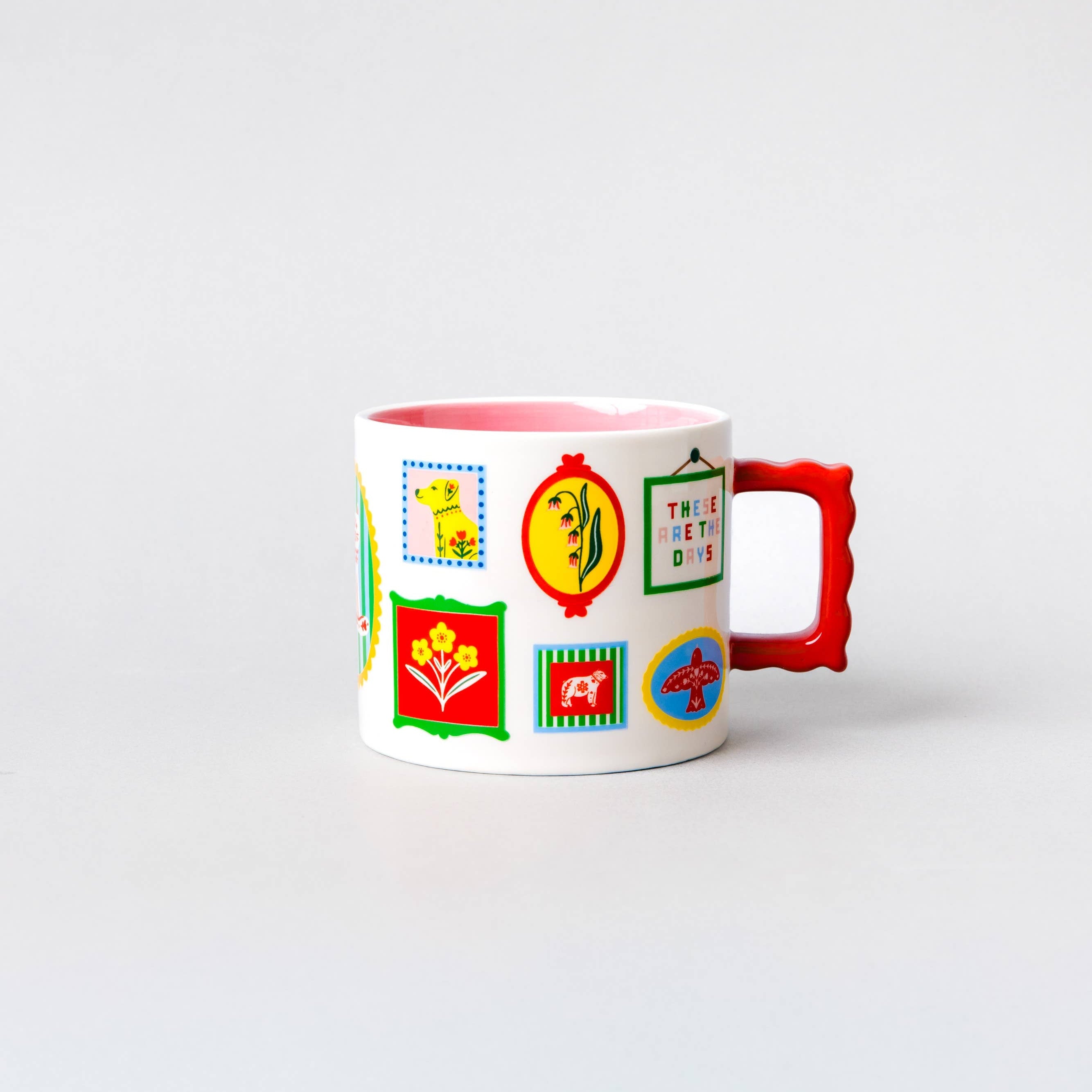 A white ceramic coffee mug featuring colorful retro-style postage stamp illustrations and a bright red handle, set against a seamless light gray background.