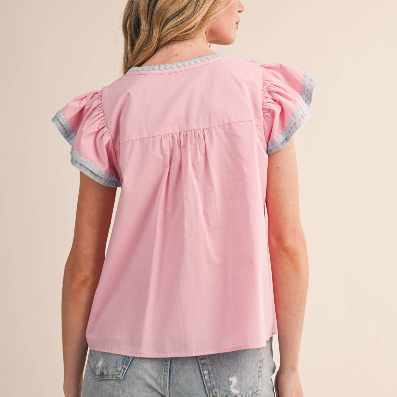 Wrap yourself in comfort with this sweet pink ruffled top that celebrates your unique style. The delicate contrast blanket triangle stitch adds thoughtful texture to the neckline, flutter sleeves, and ruffles—details designed to make you feel confident and cared for. A relaxed silhouette moves with you, while the lined construction ensures lasting comfort. Perfect for days when you want to feel both supported and beautifully yourself.