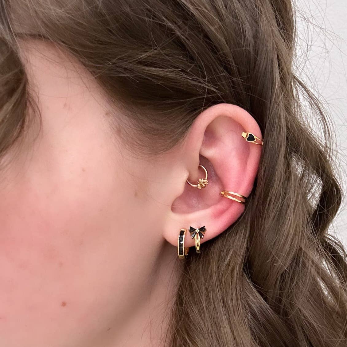 Add a touch of fun and classy to your every day by sporting these little bow huggie hoops! Bows aren't just functional and pretty knots for sealing gifts, they can represent strength, union, and beauty.
• 925 sterling silver with gold plating
• Extra layer of tarnish resistance
• Black Cubic Zirconia stones
• Manufactured for our curated collection.