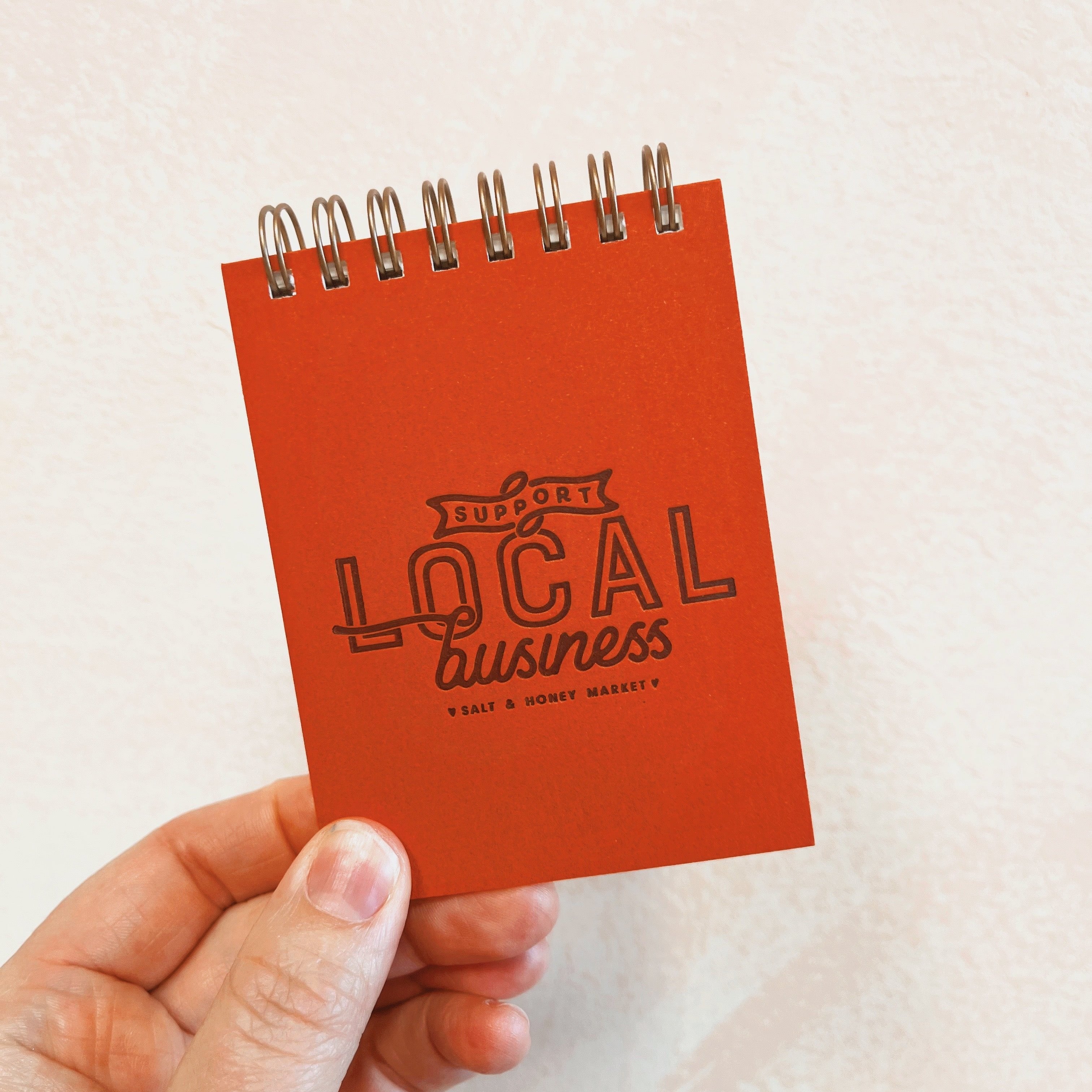 orange/red "Support Local Business" little notebook