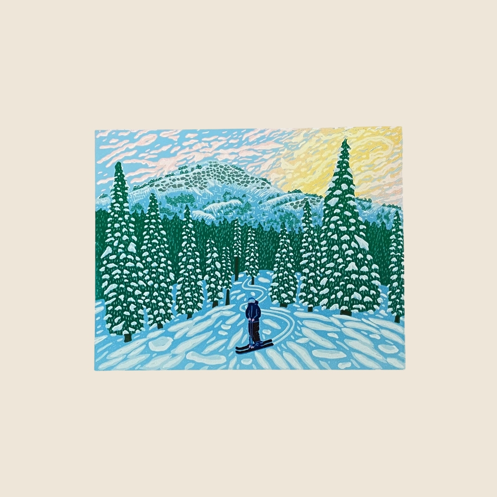 Original Artwork - Relief Print showing a skier going down the snow covered slope through snow ladden trees, in the sunset