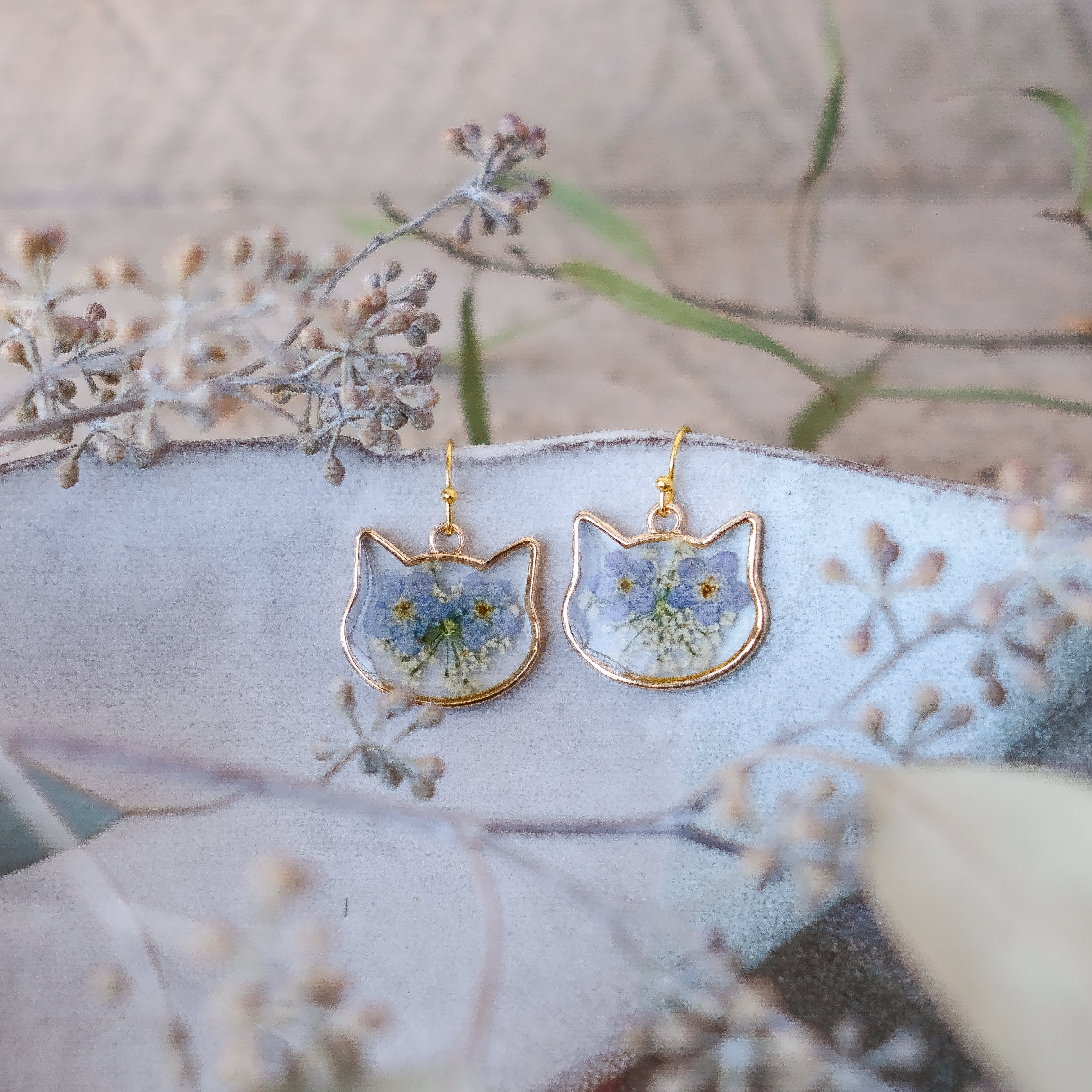 gold, cat shaped earrings with blue hand pressed flowers