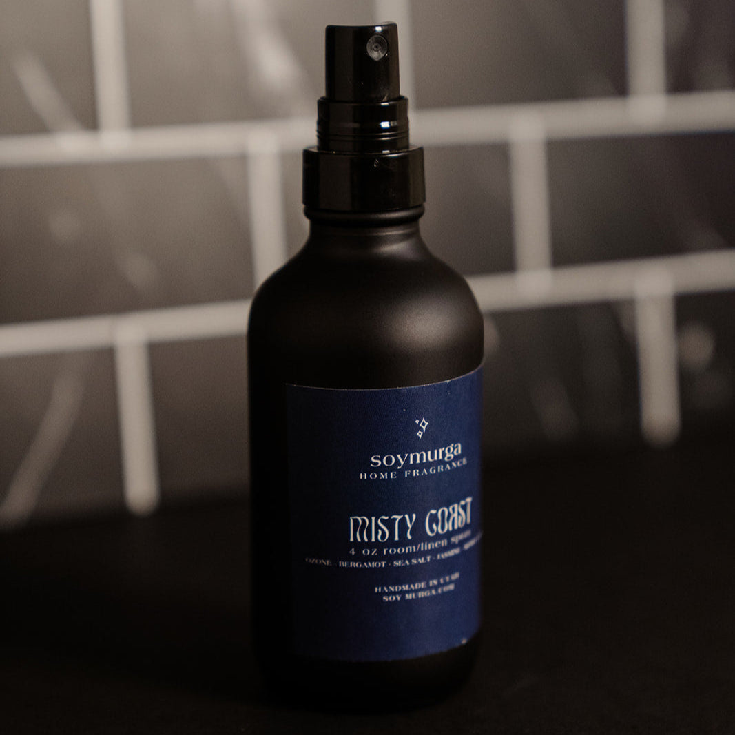 Black matte bottle with a navy label. Pictured against a black marble back splash.