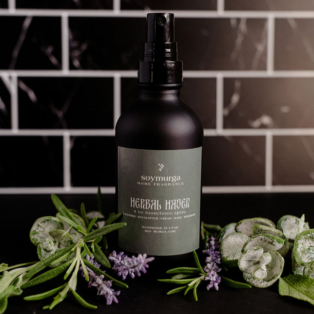 Black matte bottle with a sage green label. Pictured with assorted herbs against a black marble back splash.