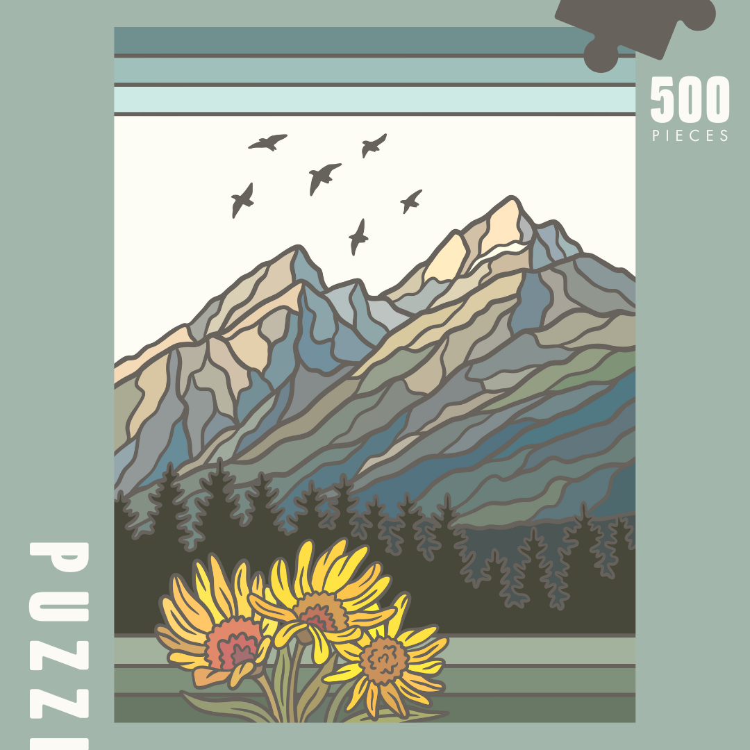 Image of puzzle box, showing full design of puzzle. Jagged mountain range in cool grey, blues, and greens. Followed by pines, and blooming arrowleaf balsam root.