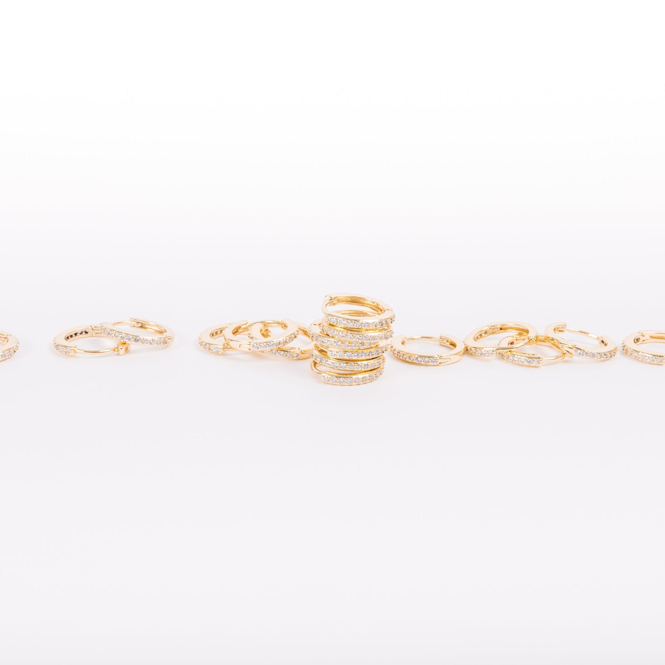 Pile of gold diamond huggies.