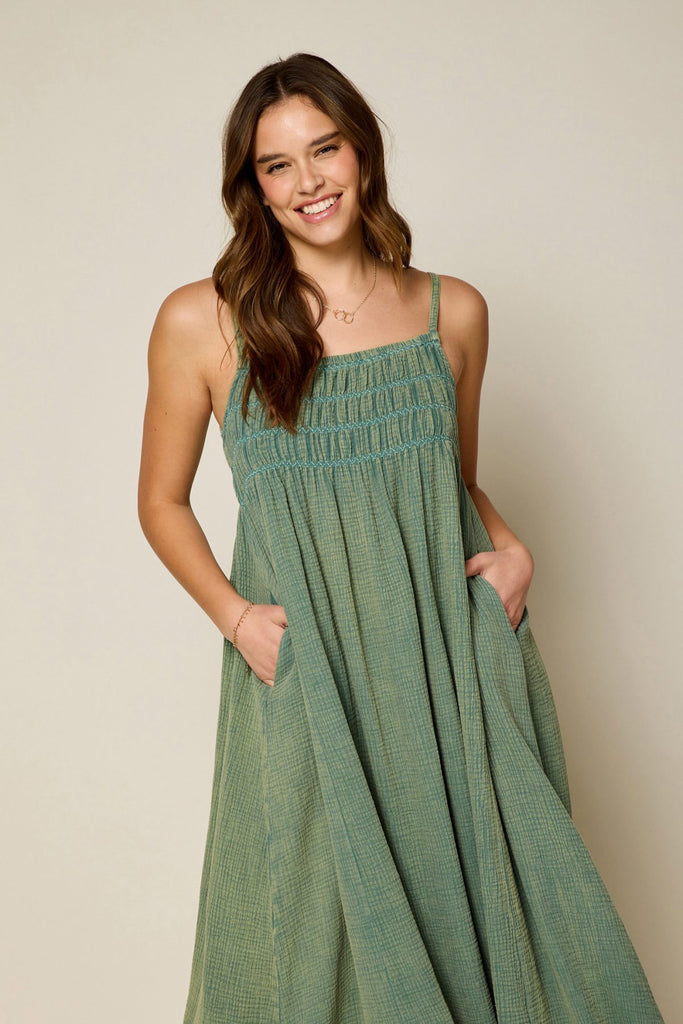 Get ready to smock and roll in this green washed cotton overall dress! The decorative smocking adds a touch of whimsy to this versatile piece. Made with soft washed cotton, it's comfortable and stylish for any occasion. Time to dress up (and down) in style!