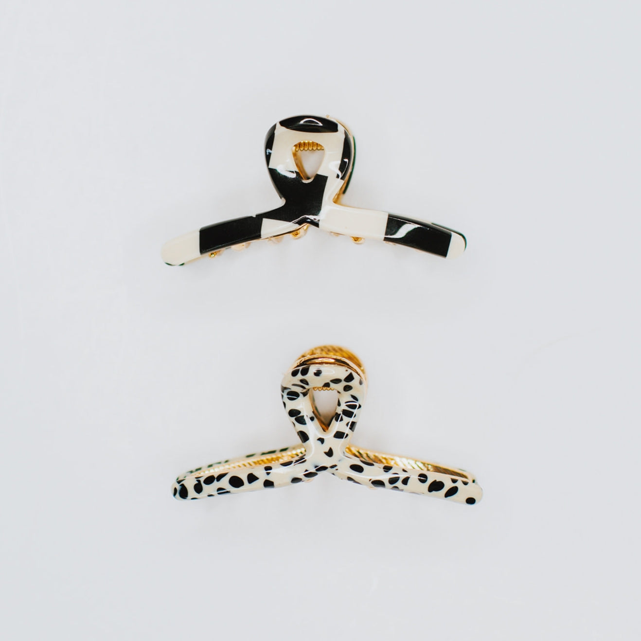 This pack includes two trendy pieces, a black checker and a spotted cream & black hair claw, both made from high-quality acetate. These hair accessories are designed to add a touch of retro flair to your look while holding your hair tightly in place. Whether you're going for a casual or formal look, these Tiny Gold Loops will be your new best friend!