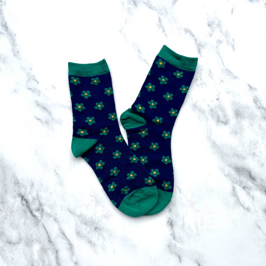 Add a touch of whimsy to your style with our Navy & Green Doodle Flower Crew Socks. The classic green daisy flower design adds a playful element, while the deep navy color gives a cozy feel. Stay comfortable and fashionable all day long!