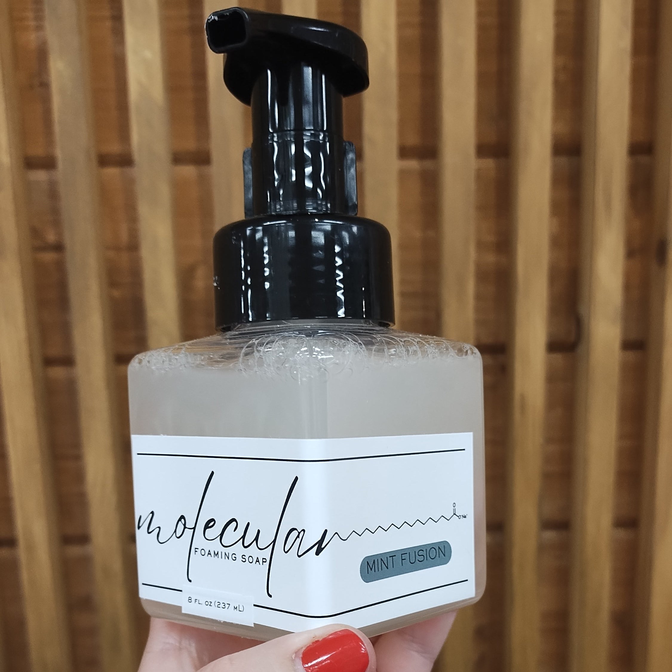 Square plastic bottle with black pump and white minimalistic label.