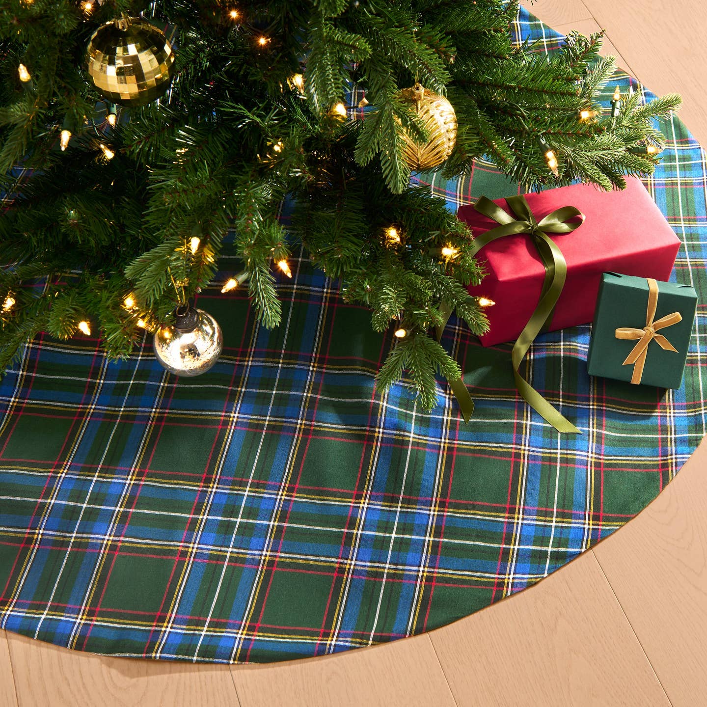 Add a touch of timeless charm to your Christmas tree with our Stowe Tartan Plaid Tree Skirt. Designed to complement a variety of holiday decor styles, this classic tree skirt features a yarn-dyed plaid pattern in two rich color palettes, showcasing shades of Christmas red, hunter green, royal blue, gold, and white. Crafted from a blend of 70% cotton and 30% recycled polyester, this product offers natural softness and a sustainable, eco-friendly option for your holiday decor.