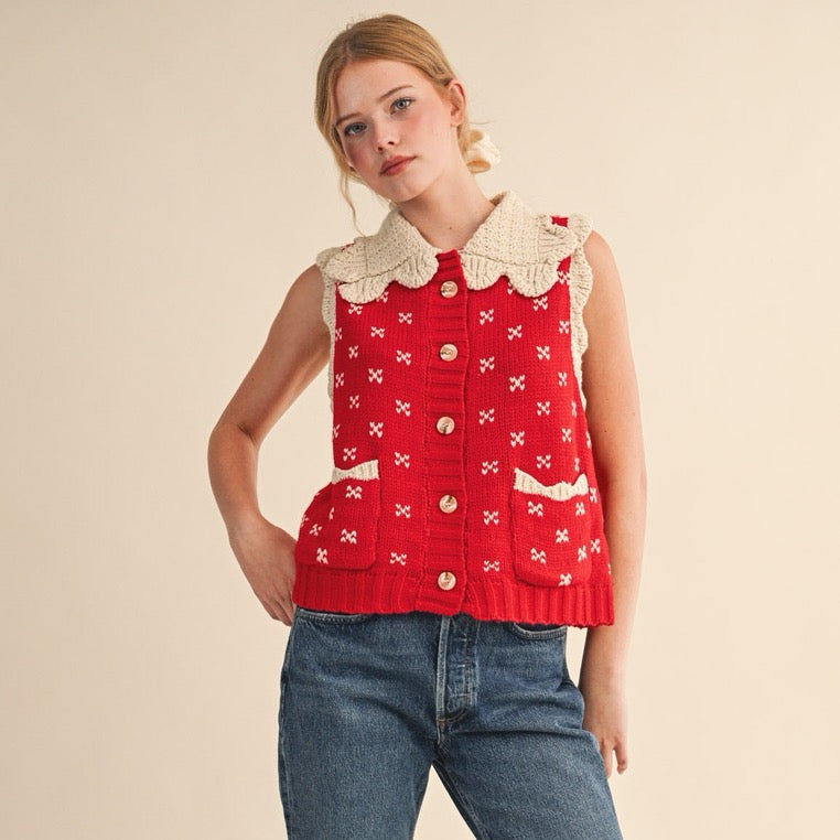 Elevate your layering game with this charming red sweater vest, designed to bring a touch of vintage-inspired style to your everyday wardrobe. The distinctive doll collar in soft oat tones creates a sweet contrast against the rich red knit, while ribbed detailing adds texture and structure. Perfect for pairing over long-sleeve tees or delicate blouses, this versatile piece works beautifully for casual outings or dressed-up occasions. The quality knit construction ensures lasting comfort and durability.