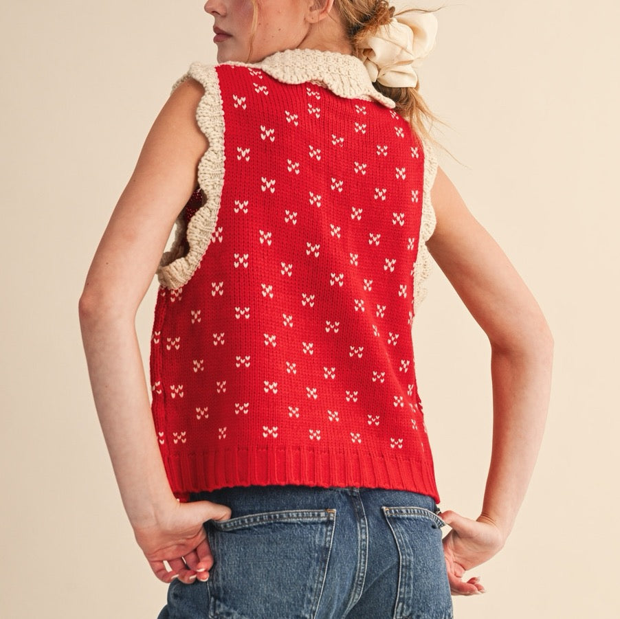 Elevate your layering game with this charming red sweater vest, designed to bring a touch of vintage-inspired style to your everyday wardrobe. The distinctive doll collar in soft oat tones creates a sweet contrast against the rich red knit, while ribbed detailing adds texture and structure. Perfect for pairing over long-sleeve tees or delicate blouses, this versatile piece works beautifully for casual outings or dressed-up occasions. The quality knit construction ensures lasting comfort and durability.