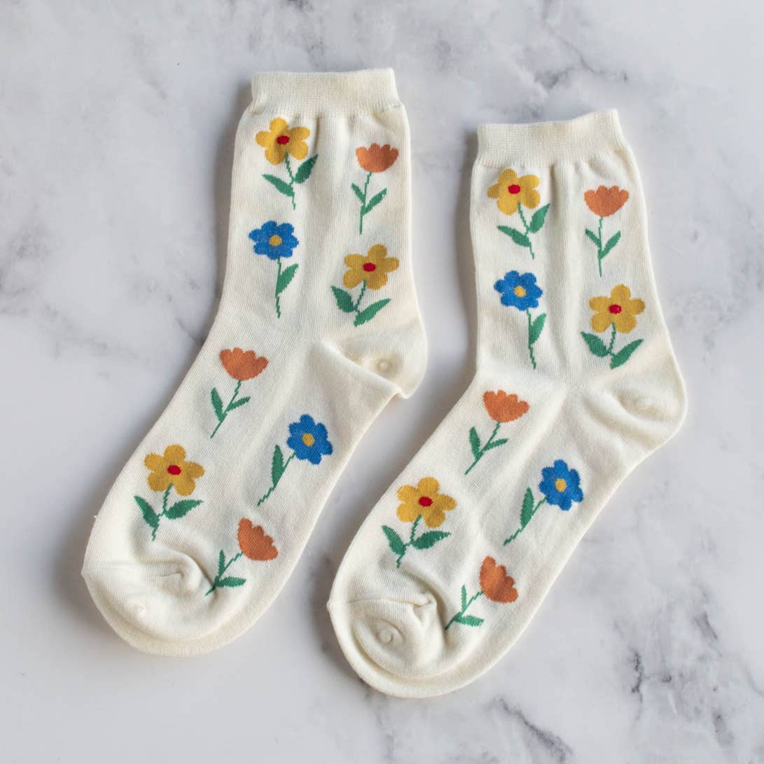 Bloom into style with our Favorite Flower Socks! These adult socks feature a dainty flower pattern on a subtle cream background. Spread some joy and flower power on your feet with these quirky and playful socks. (Socks may cause spontaneous dancing and increased joy levels.)