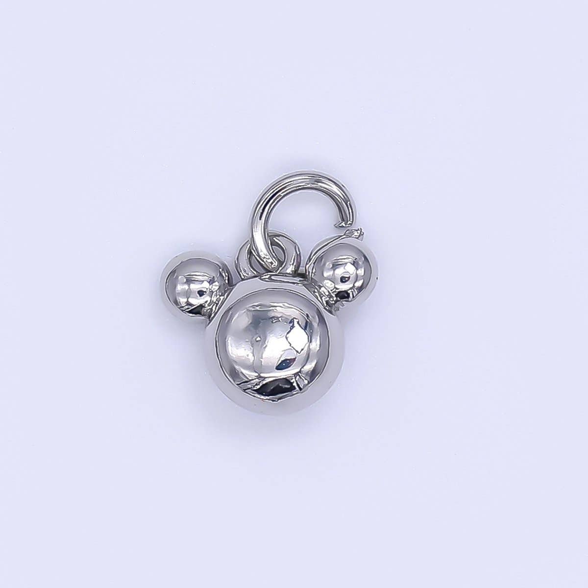 Adorable mouse ears charm crafted from brass and gold-filled materials. This delicate pendant features a polished silver finish and petite dimensions perfect for layering on bracelets, necklaces, or charm chains. Safe for sensitive skin—lead-free and nickel-free construction. An enchanting addition to any jewelry collection.