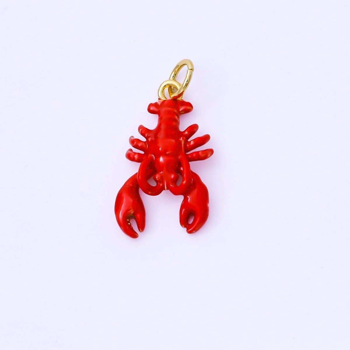 Vibrant red enamel lobster charm crafted from brass with 24K gold-filled accents. This versatile piece measures 20.1mm x 11.5mm x 3.6mm, making it perfect for bracelets, necklaces, or charm collections. Lead-free and nickel-free for safe, comfortable wear. Add a pop of coastal charm to your jewelry designs.