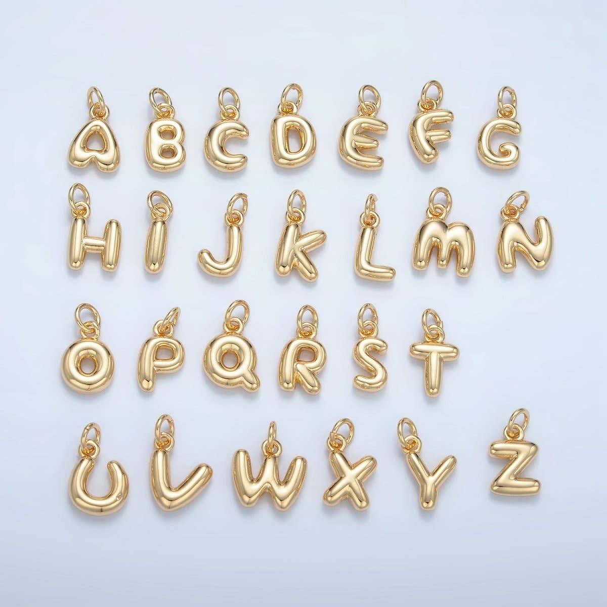 Charming brass letter charms styled as playful balloon letters in gleaming 16K gold plating. Each letter of the alphabet is available, letting you spell out initials, names, or meaningful words on bracelets, necklaces, and charm accessories. These miniature charms measure 11mm x 6mm x 2.5mm, making them perfect for delicate jewelry designs and layering. Crafted from quality brass with gold plating, they maintain their lustrous finish through everyday wear.