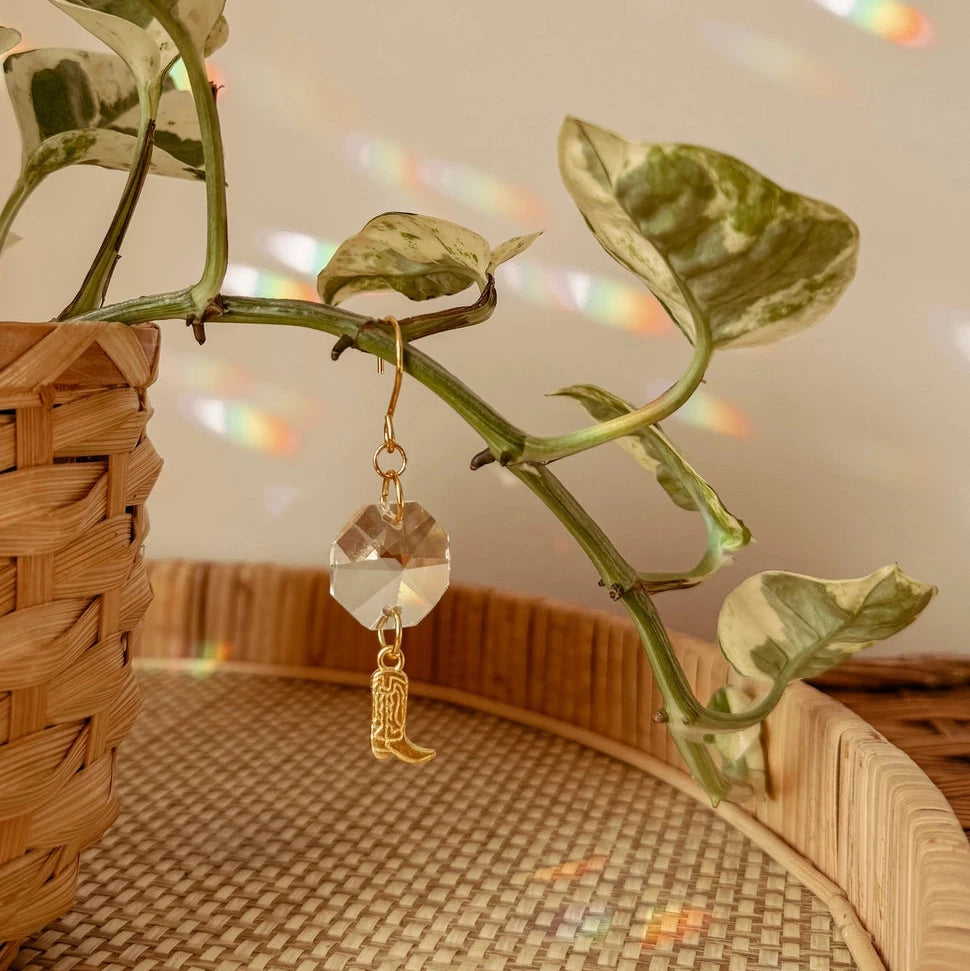 These delicate plant charms hang gracefully from vines, featuring a brass cowboy boot charm and suncatcher crystal. As direct sunlight hits the crystals, sparkles dance around to create a dreamy, light-filled atmosphere. Perfect for hanging on vines or trailing plants! Coordinates beautifully with natural, bohemian, minimal, hippie, retro, & whimsical decor styles.