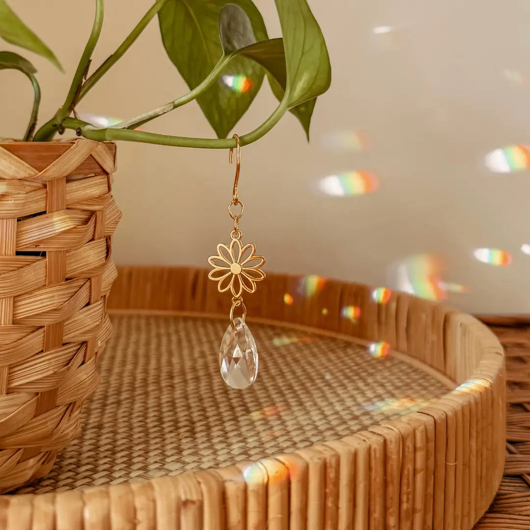 These delicate plant charms hang gracefully from vines, featuring a brass flower charm and suncatcher crystal. As direct sunlight hits the crystals, sparkles dance around to create a dreamy, light-filled atmosphere. Perfect for hanging on vines or trailing plants! Coordinates beautifully with natural, bohemian, minimal, hippie, retro, whimsical decor styles.