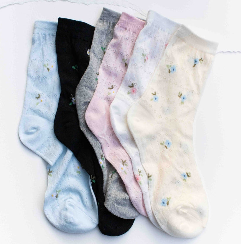 Delicate and charming, these mini floral socks add a soft touch of color to everyday outfits. Featuring scattered tiny flower details on breathable cotton fabric, they offer both comfort and subtle style. Perfect for pairing with sneakers, loafers, or casual shoes for a fresh, feminine look.