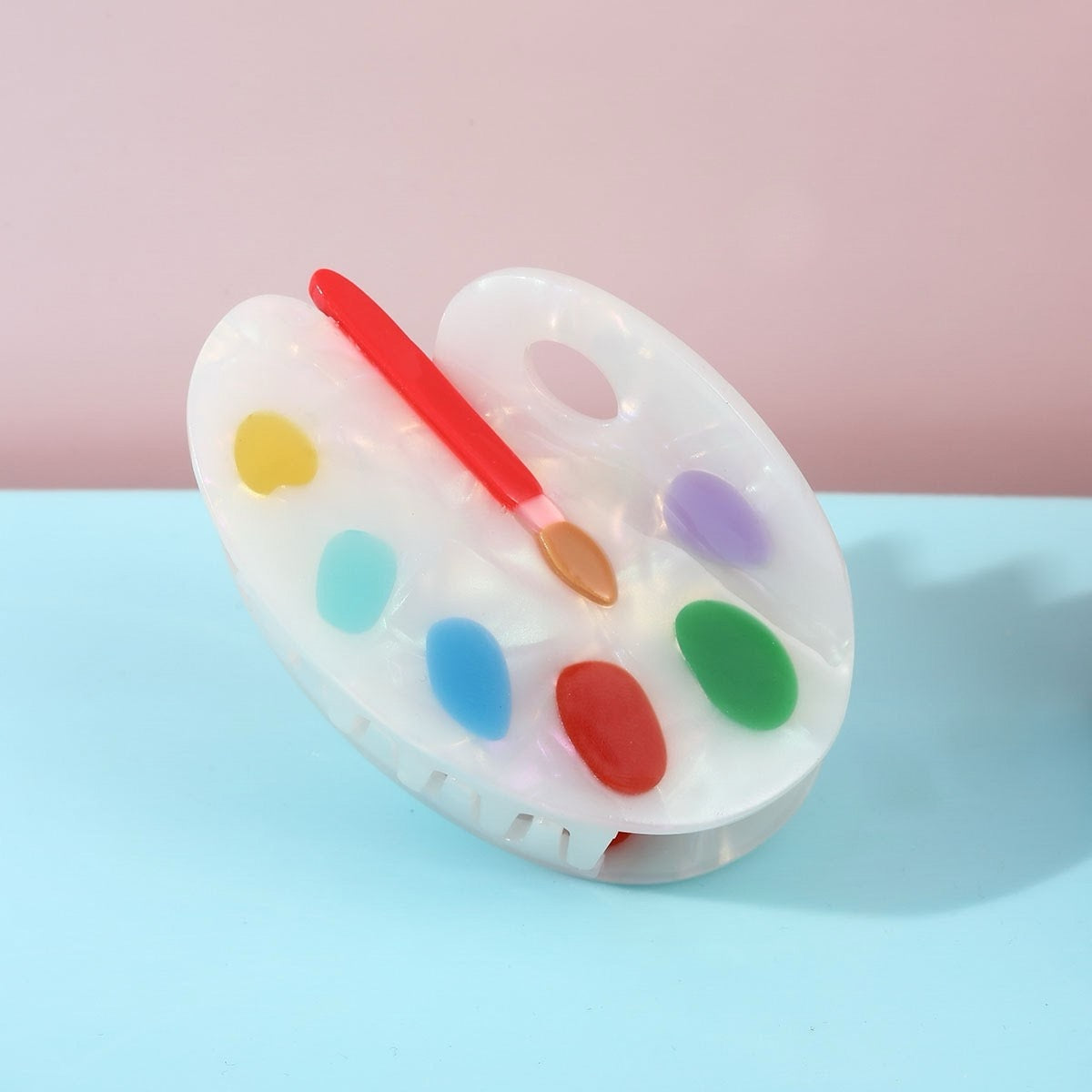 Add a touch of whimsy to your hairstyle with these adorable hair claws! Featuring a darling paint palette design and made of quality materials for a secure hold. Perfect for keeping your hair in place while adding a fun, artistic flair to your look. A must-have for anyone who loves unique and charming hair accessories.