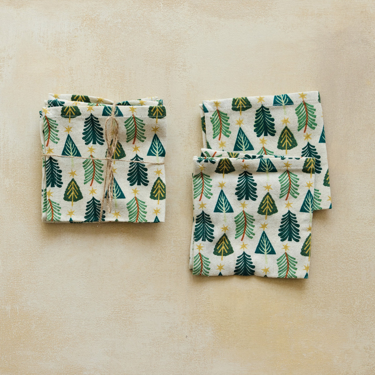 Bring festive warmth and hospitality to your gatherings with this set of four cotton and linen cocktail napkins. Featuring a charming printed tree pattern and neatly tied with natural jute cord, they offer a cozy, elegant touch to your seasonal table settings.