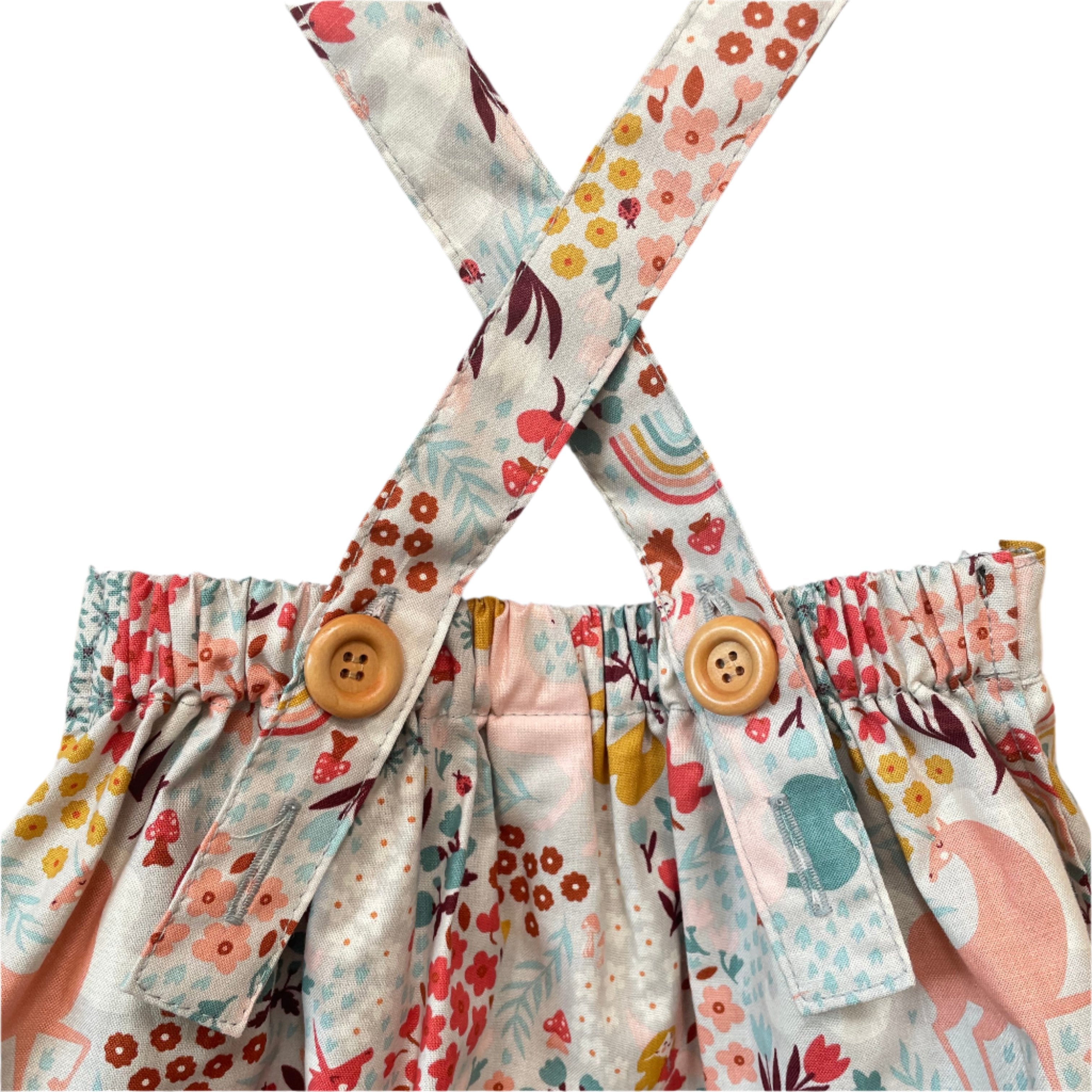 The Andi mini trouser skirt has adjustable suspenders with a button on the back. Two button holes are sewn on each suspender strap so your child can grow with their skirt making it easy to wear high on her waist when they are younger & on their natural waist when older. Fabric designed by Ashley Collett for Riley Blake.