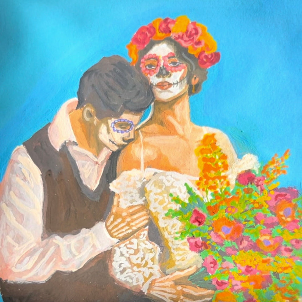 An illustration shows a close embrace between a man in a white shirt and dark vest and a woman with Día de los Muertos face paint, orange and pink flower crown, and a white lace dress, clutching a colorful bouquet of marigolds and roses against a solid turquoise background. The couple's tender pose highlights themes of love and remembrance in a festive, cultural style.