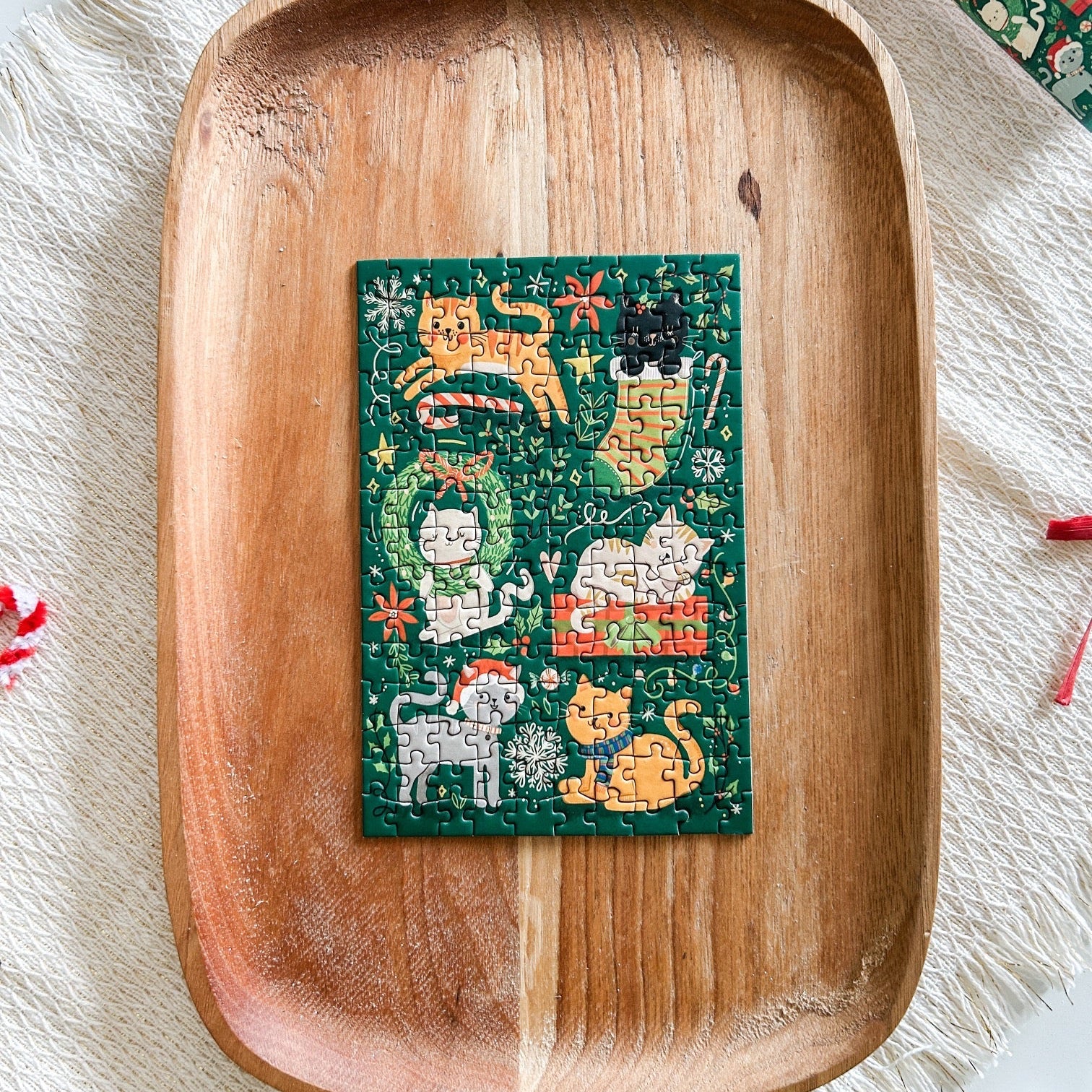 Mini puzzle completed resting on a wooden tray. Puzzle has 6 kitties playing with Christmas decor and gifts.