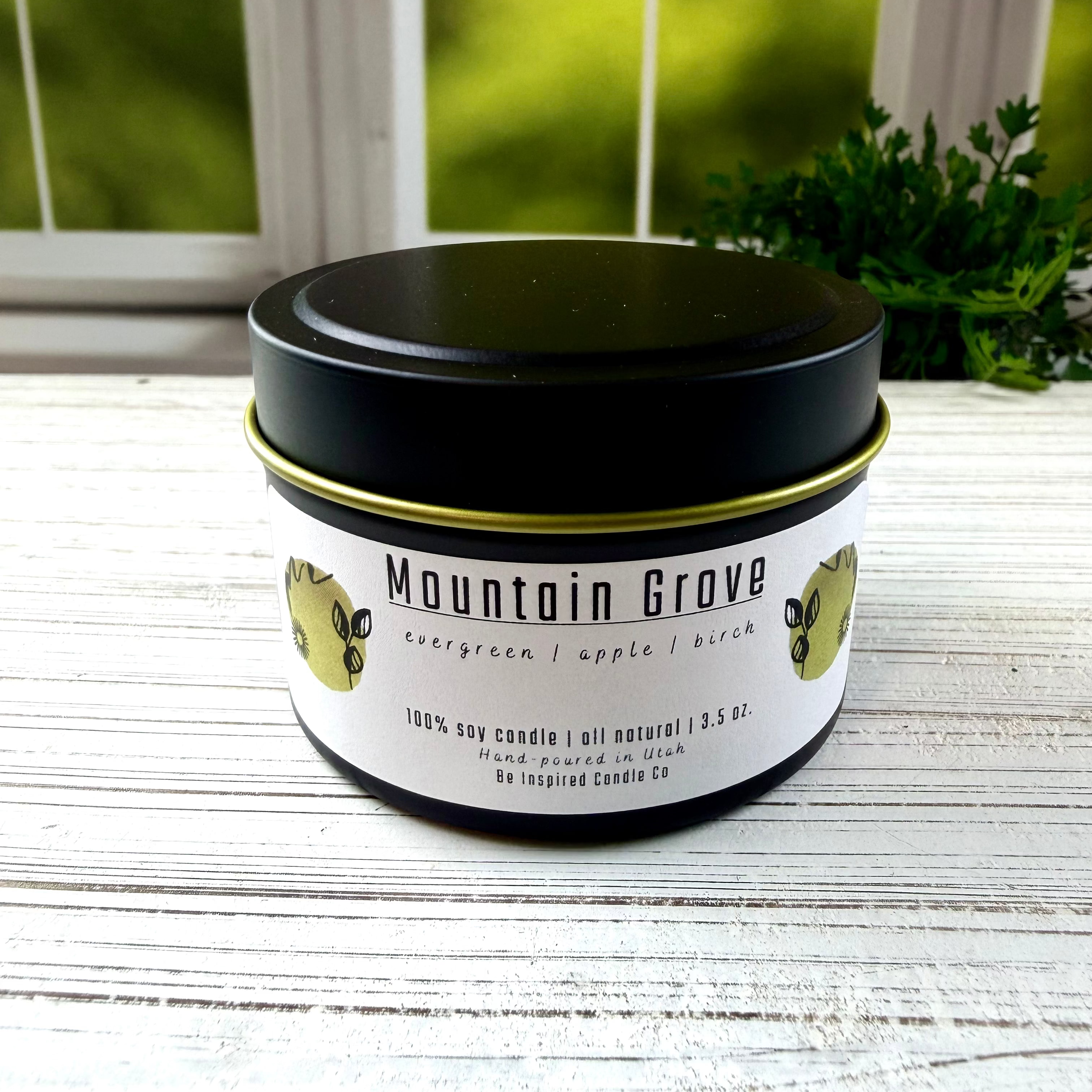 Black tin candle with white label.