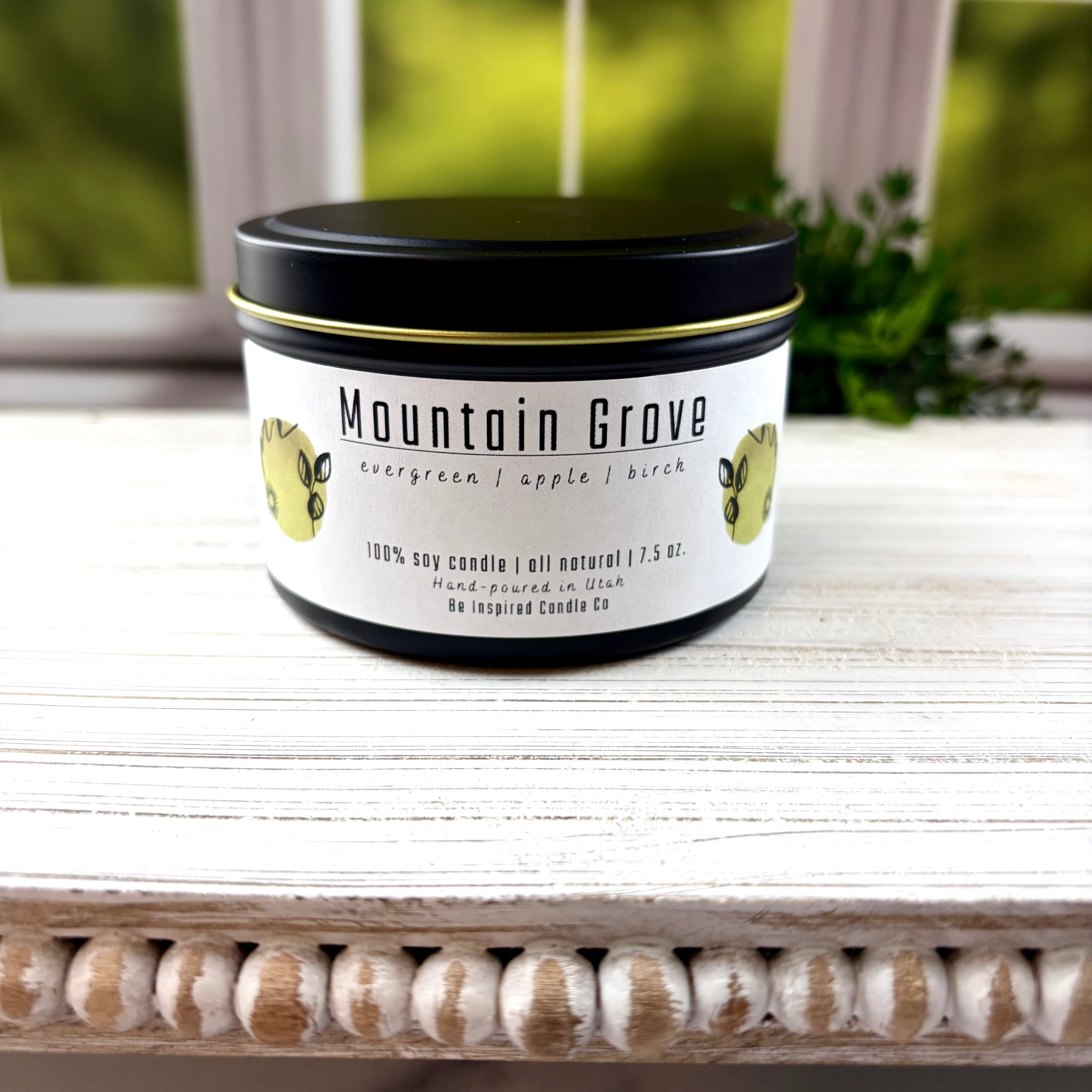 Black tin candle with white label.