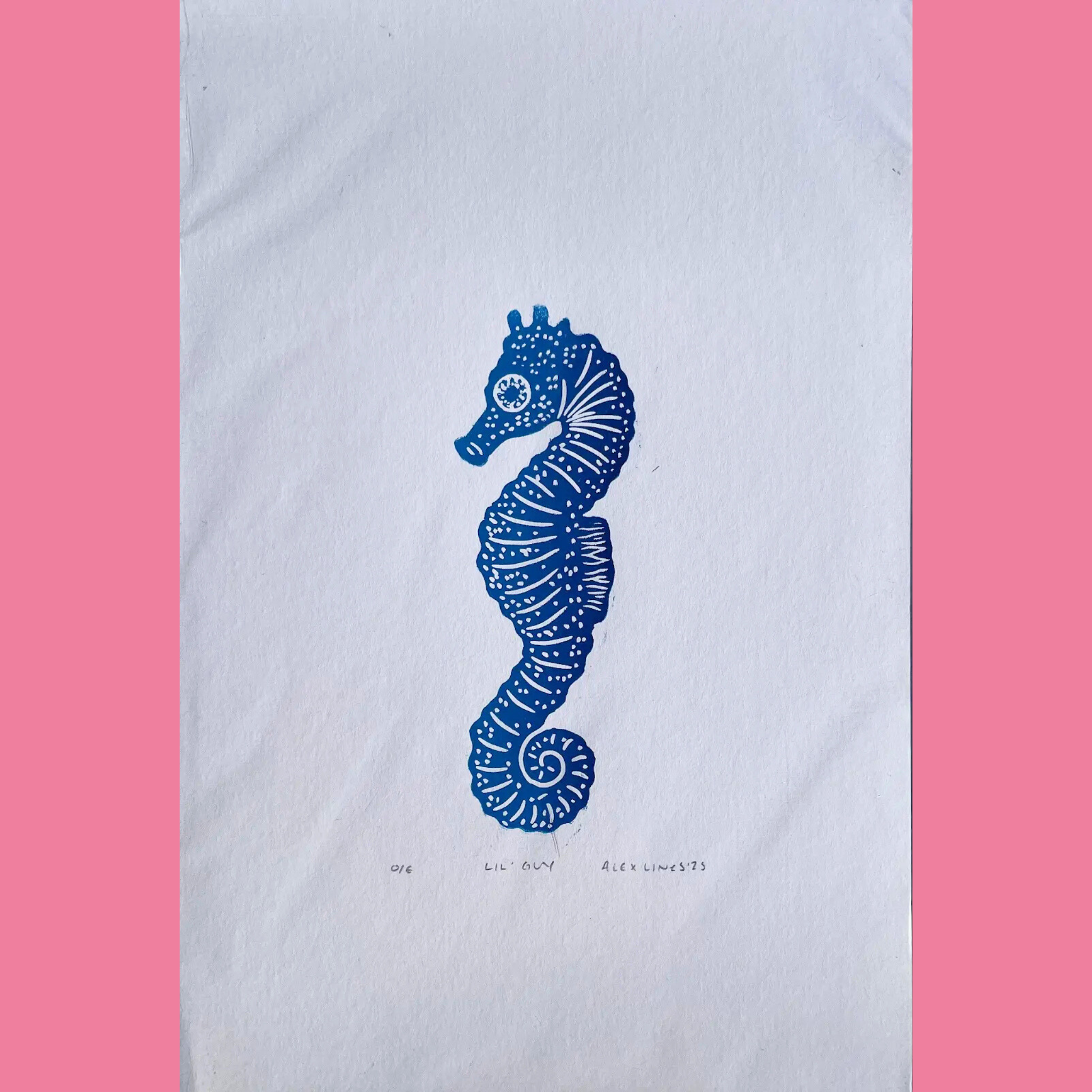 A bold blue linocut print features a single, upright seahorse centered on the page, intricately detailed with swirling white line patterns along its curled tail, segmented body, and crown-like head, plus a large circular eye. The artwork is printed on white paper with the number "016," the title "LIL' GUY," and the signature "ALEX LINES '25" handwritten below, surrounded by a bright pink border.