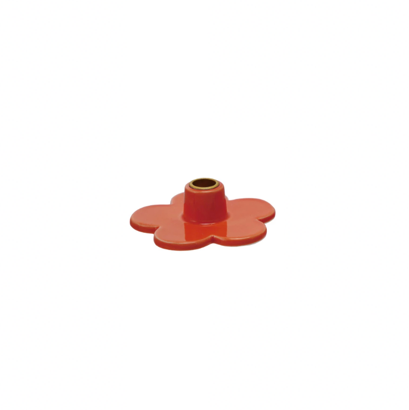 Add a touch of whimsy to your decor with our Stoneware Flower Shaped Taper Holder, available in 3 colors. This holder not only holds your taper candles securely, but also doubles as a charming tabletop accent. Brighten up any room with this playful and unique piece! 3"L x 3"W. Orange