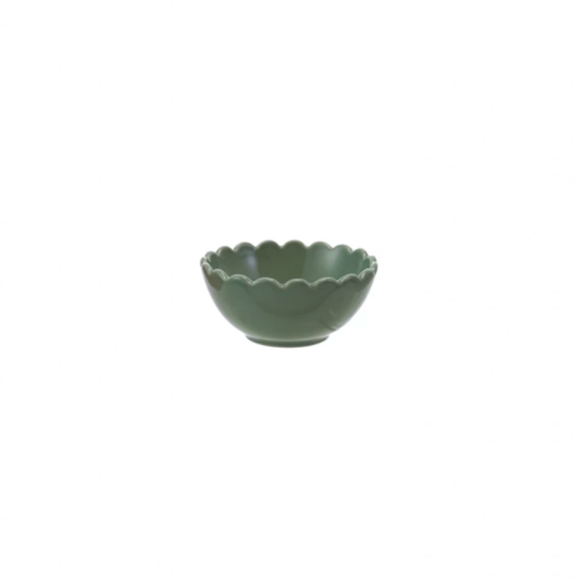 Green ceramic bowl with scalloped edge on a white background