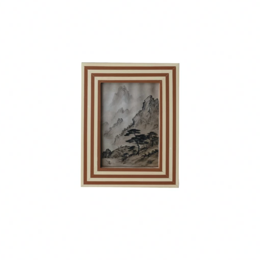 Rust colored striped Framed artwork of a mountain landscape on a white background