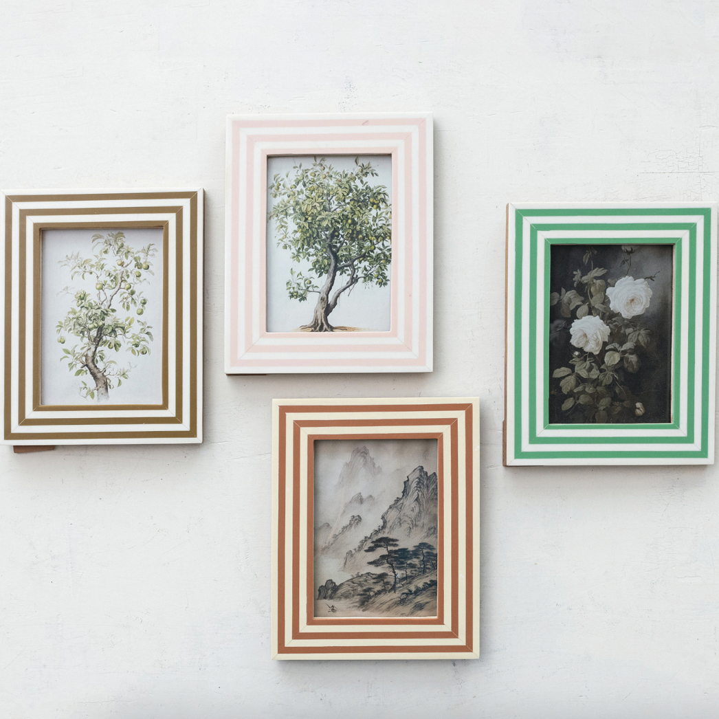 Four framed artworks on a white wall