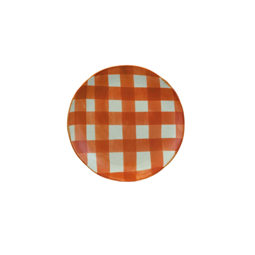 A round plate with a classic orange and gingham checkered pattern, photographed from directly above on a solid white background.