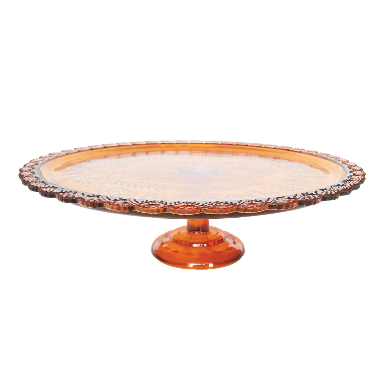 An amber glass pedestal cake stand with a scalloped rim and a round base, shown on a plain white background.