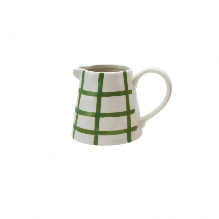 A small white ceramic pitcher with a green hand-drawn plaid pattern, set against a solid white background.