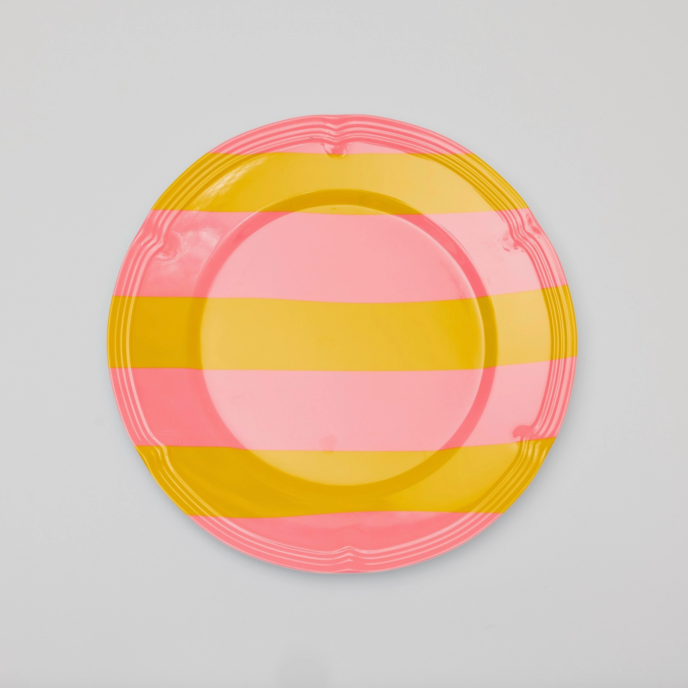 A pink and yellow striped melamine plate.