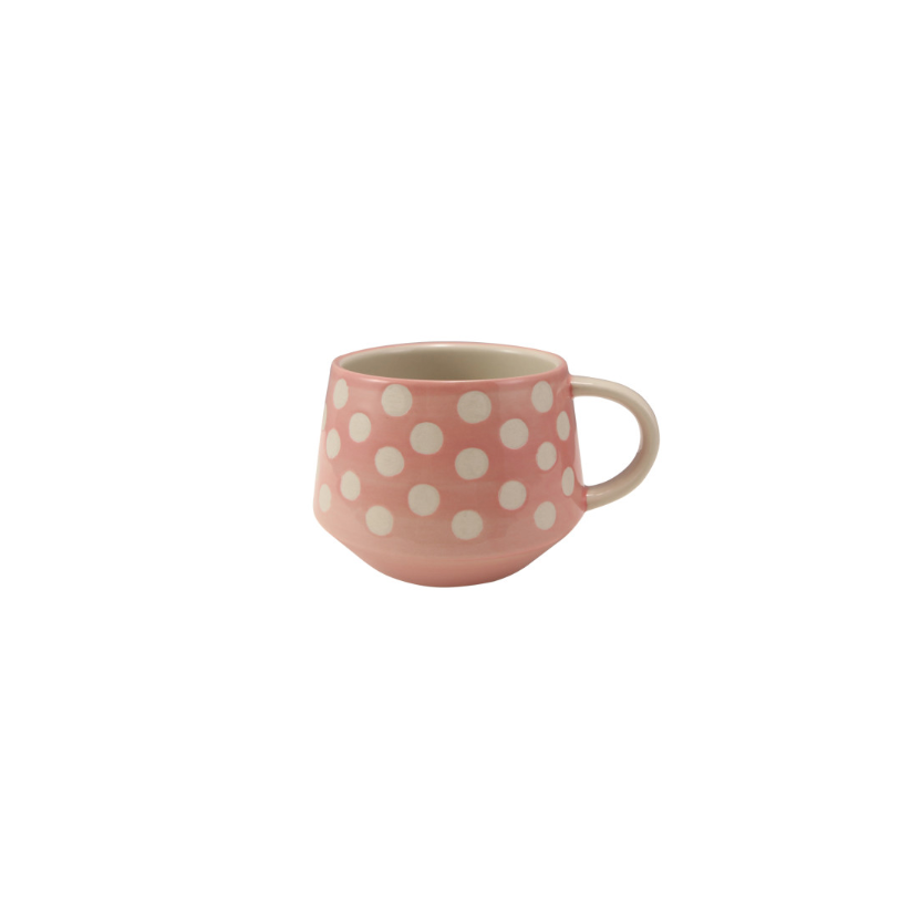 Pink mug with white polka dots on a white background