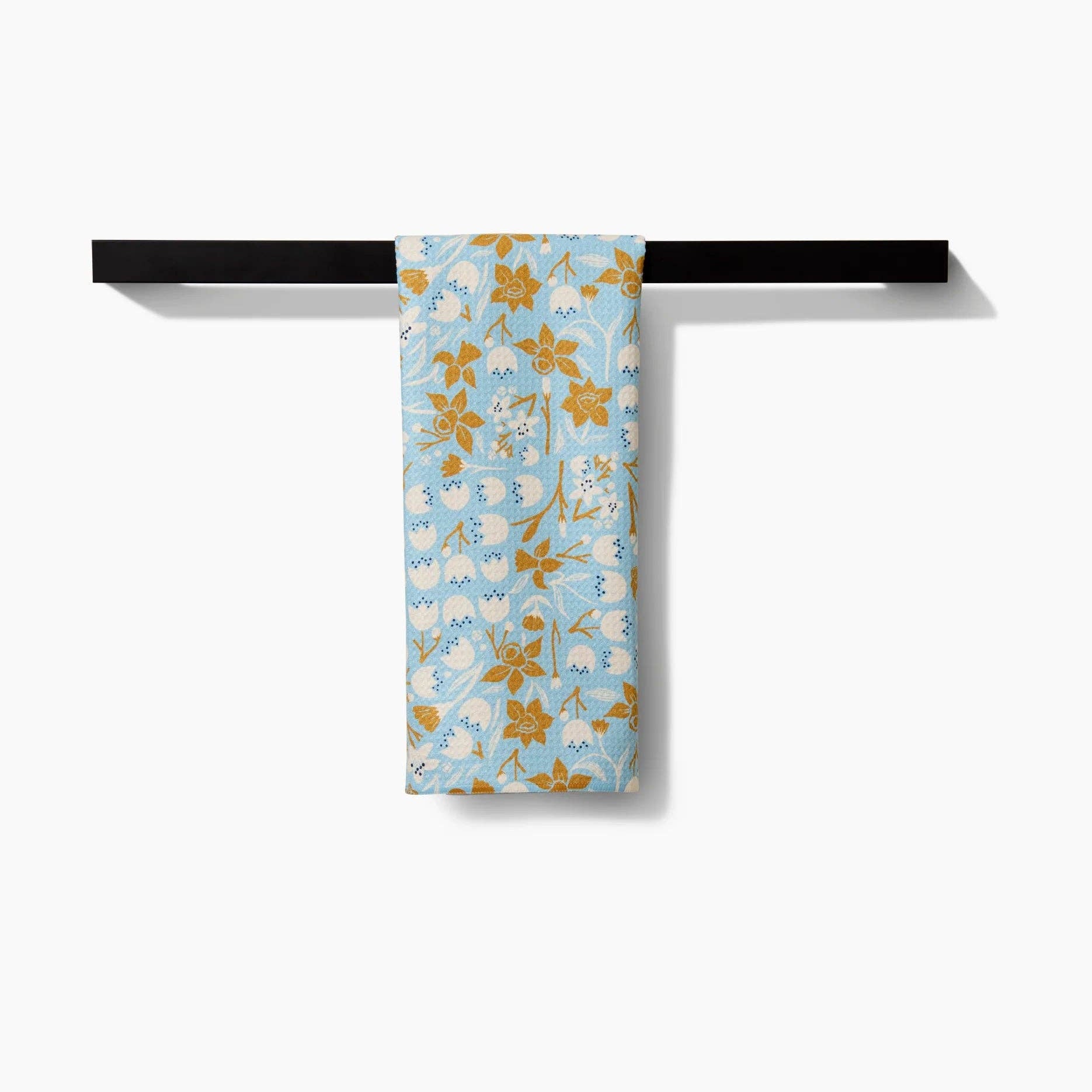 Floral-patterned towel hanging on a black towel rack against a white background Tea Towel