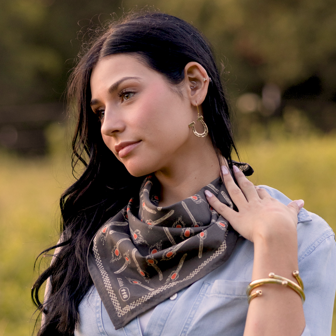 Woman wearing a patterned scarf outdoors with a blurred natural background