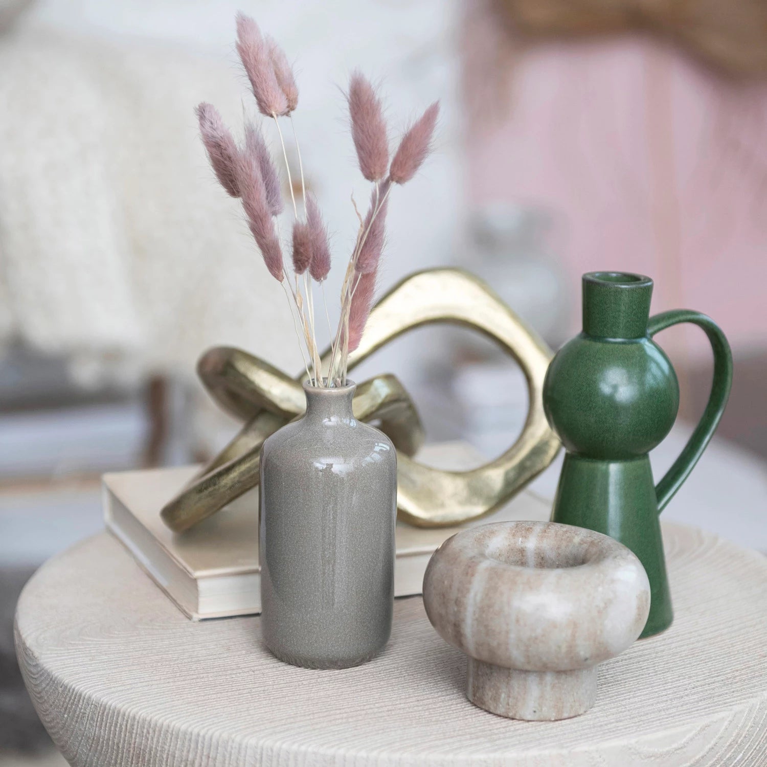 Illuminate the home with this green stoneware taper holder with a handle. This candle holder features a stoneware construction that has a reactive glaze that creates a beautiful variation of green hues. The candle holder has a unique shape that resembles a jug with a handle, adding some personality and flair to any space.