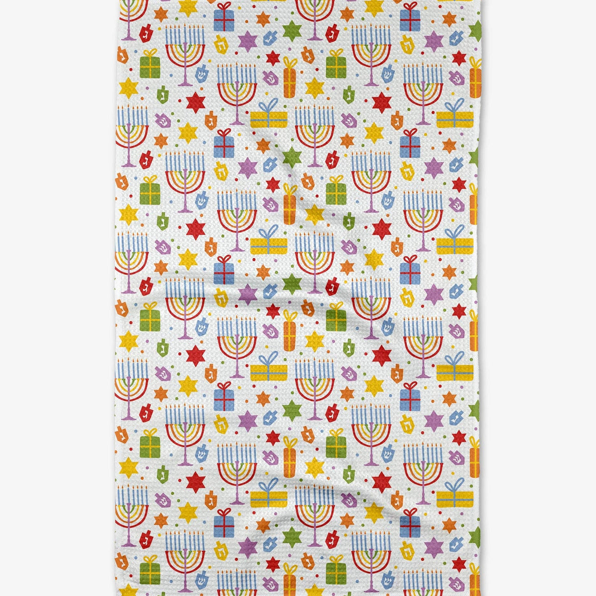 A rectangular white kitchen towel or tea towel featuring a colorful repeating pattern of Hanukkah menorahs, stars, gift boxes, and confetti.