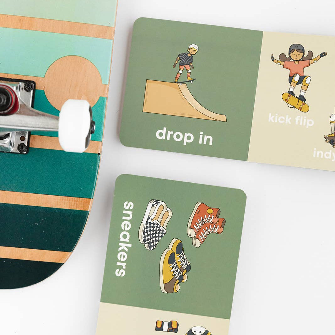 Skateboard with a deck featuring illustrations of sneakers and a 'drop in' graphic on a white background.