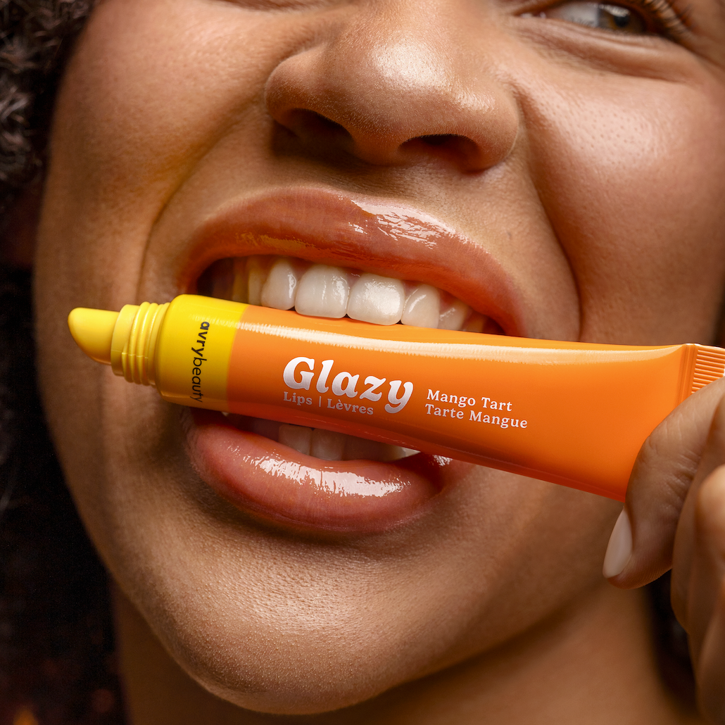 Person holding a Glazy Mango Tart tube near their mouth