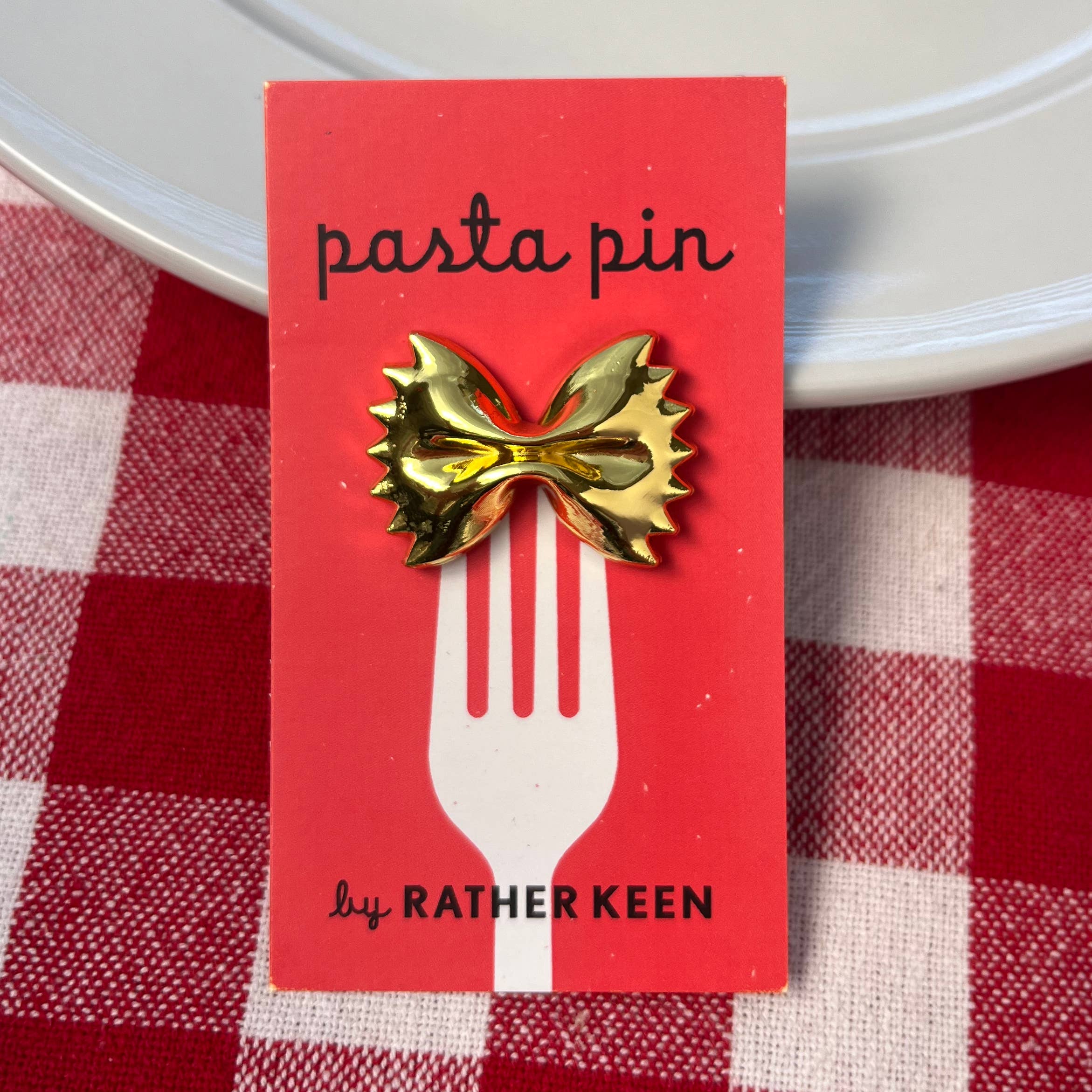 A golden replica of farfalle fashioned into a pin. Pasta pizzazz for your lapel or your bag!
Details:
1.25 x 7/8 inch (30 x 22 mm)
gold-tone metal
Comes mounted on a display card with a rubber clasp.