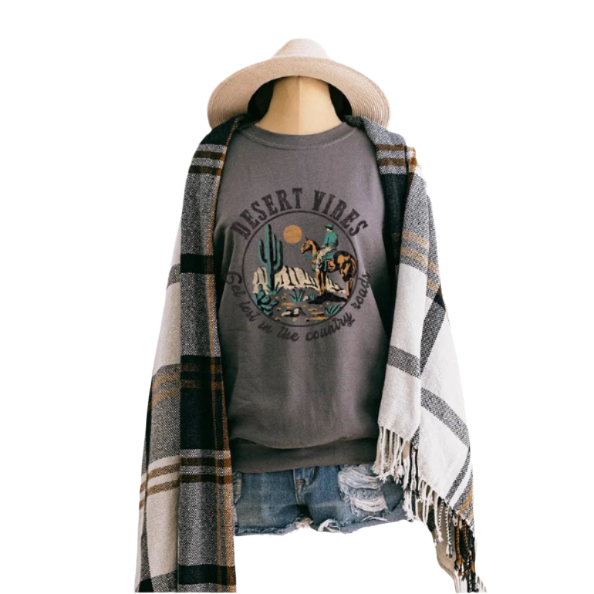 Mannequin wearing a gray sweatshirt with a desert-themed graphic, denim shorts, and a plaid shawl on a white background.