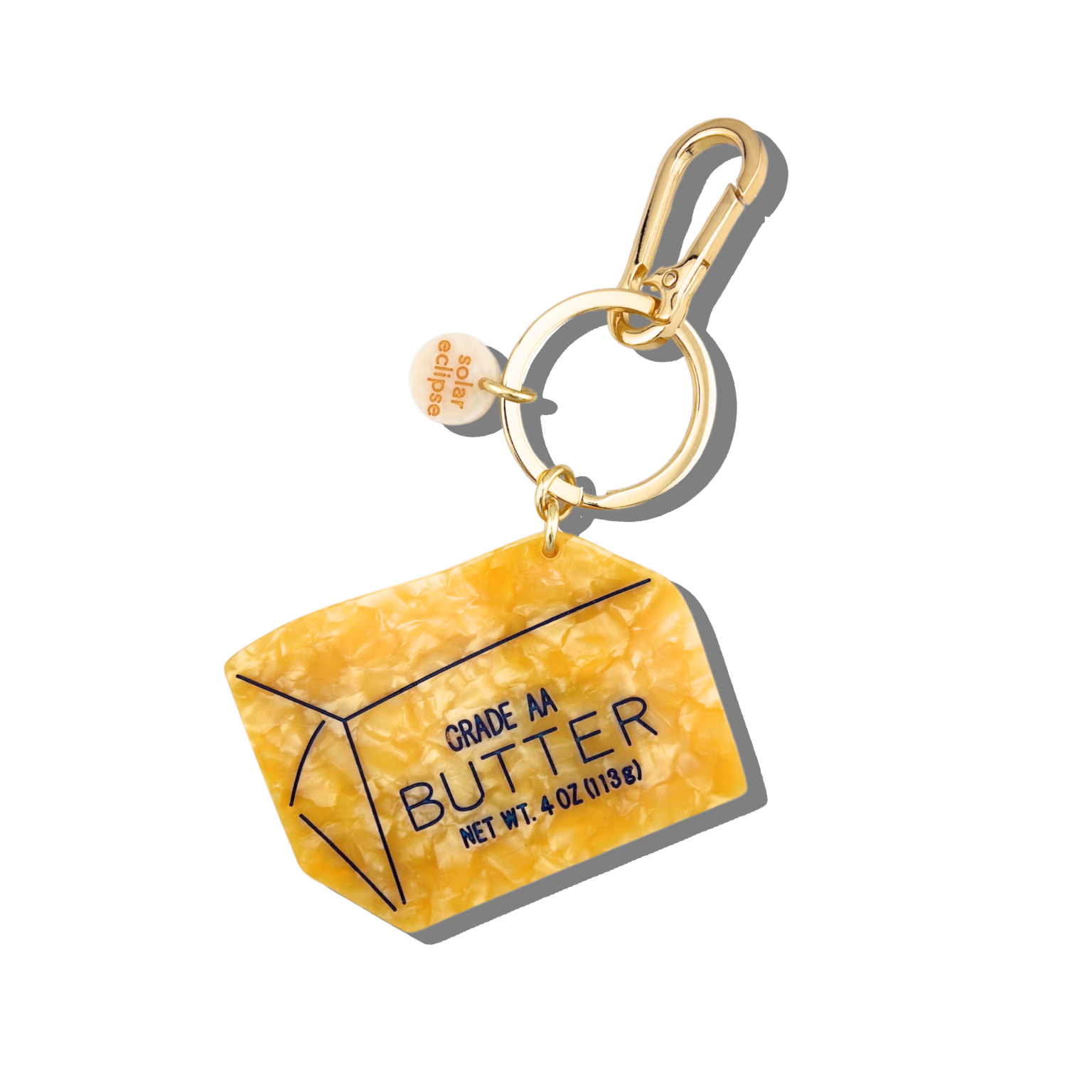 Butter container keychain with gold clasp on a white background